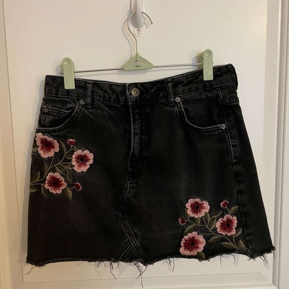Black mini jean skirt with embroidered pink flowers. Topshop size 6.